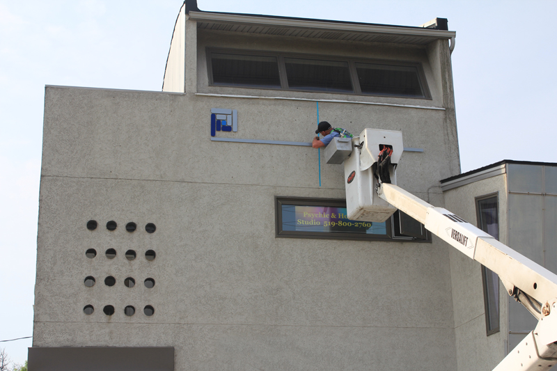 Rolan Neon Signs installing Solid Foundation Chiropractic's Sign